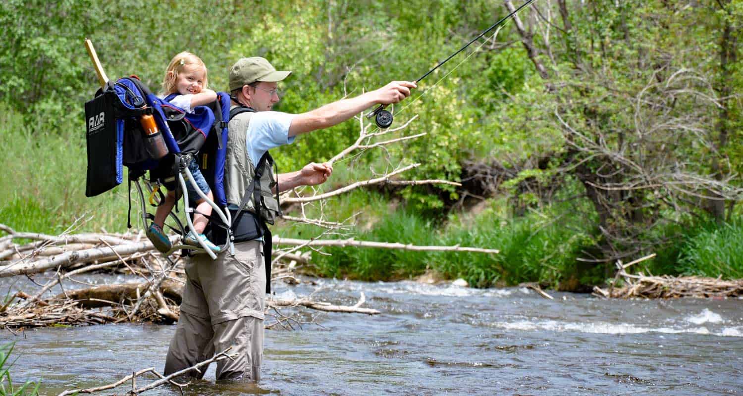 aaron johnson author of dayhikes near denver with daughter in backpack flyfishing on bear creek at Lair o the Bear Park near morrison colorado