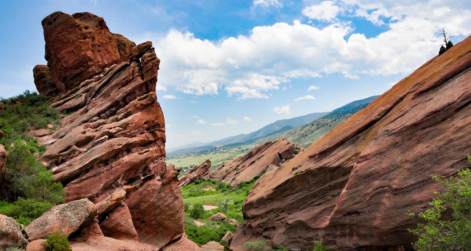 red rocks with blue sky background and green trees along trading post trail red rocks park in Denver Colorado
