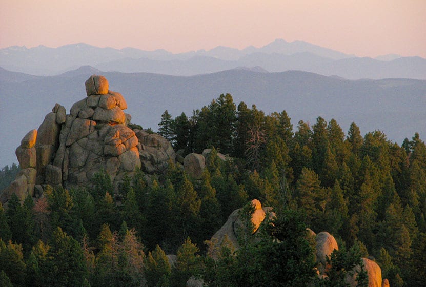 Rock formations in foreground and Longs peak in background at Devils Head Lookout firetower on hike near Denver Colorado