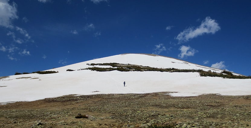 man hiking up snow covered st. vrain mountain in colorado