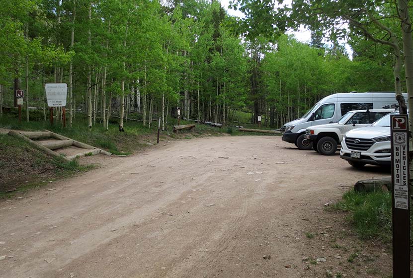 parking area at st. vrain mountain trailhead in colorado aspen trees and dirt road