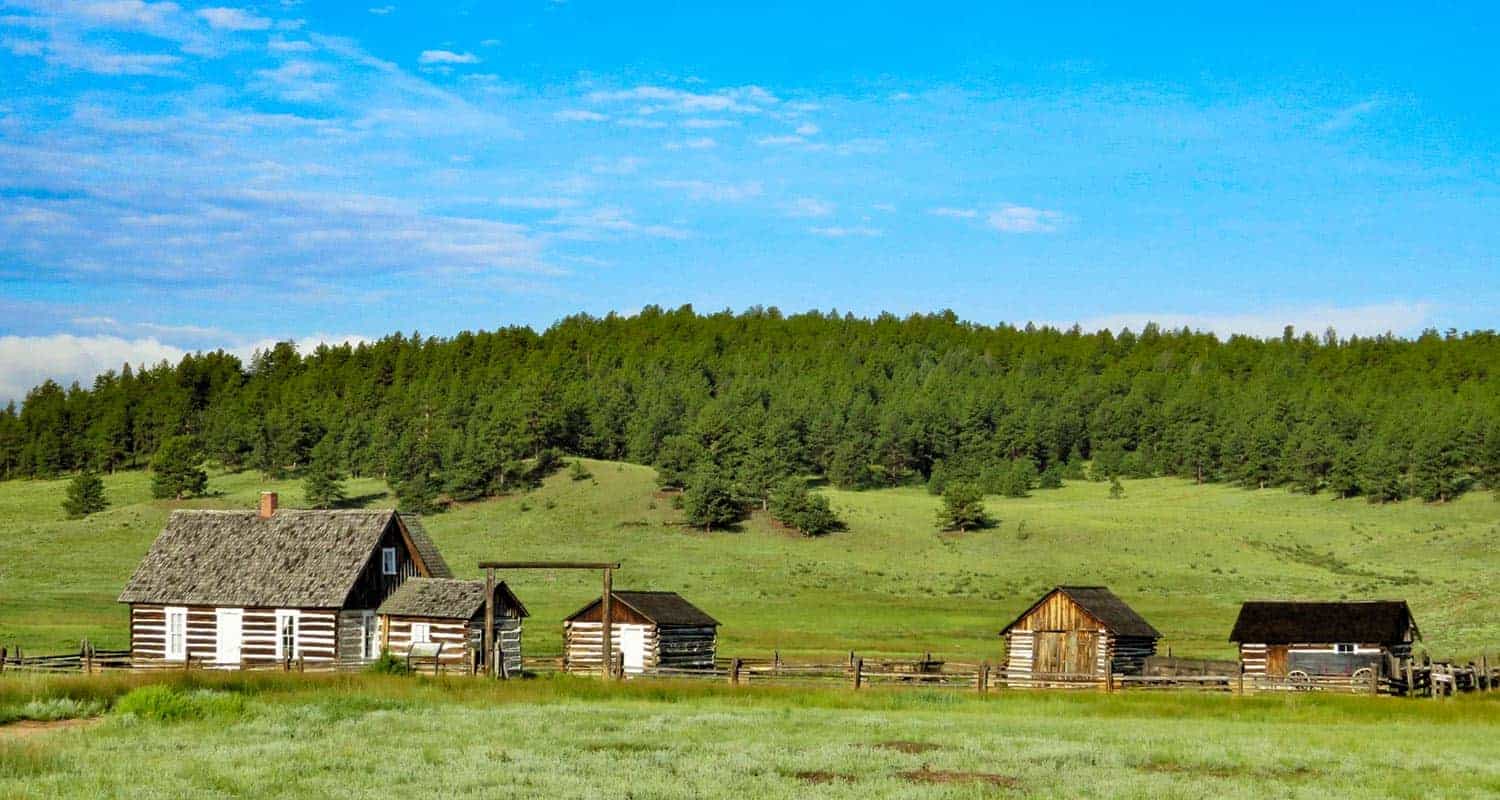 old cabin with barns in florissant colorado with green meadows hornbeck homestead at fossil beds national monument
