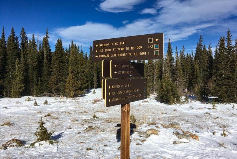 brainard lake waldrop trail signage with snow on ground and evergreen trees in background