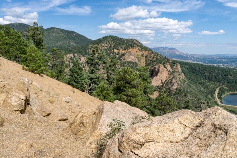 view from the summit of mt. cutler with granite rock in foreground and foothills in background near colorado springs