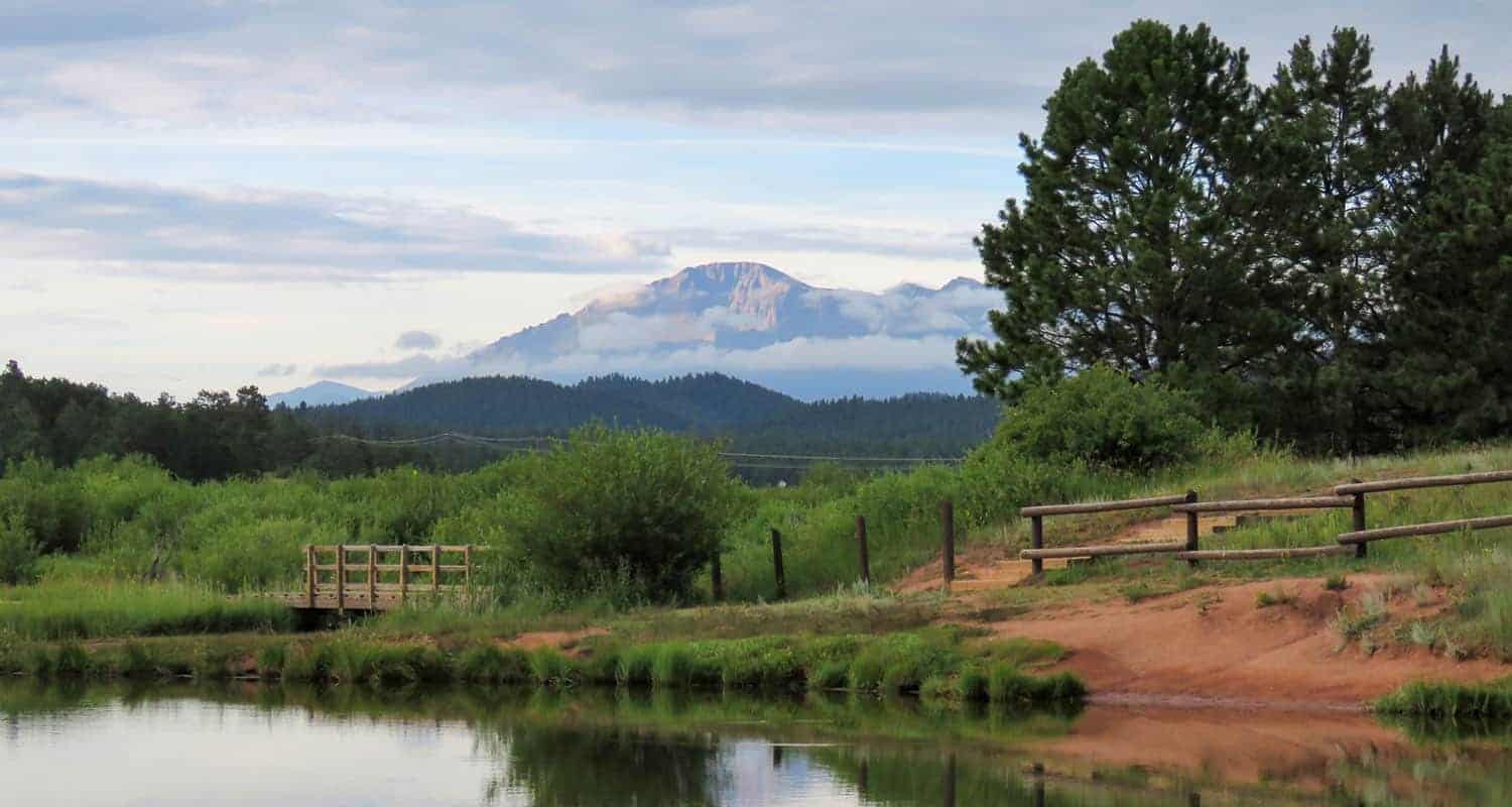 pikes peak in background with manitou lake in foreground near colorado springs